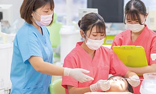 歯科診療の流れを実技で教わる学生